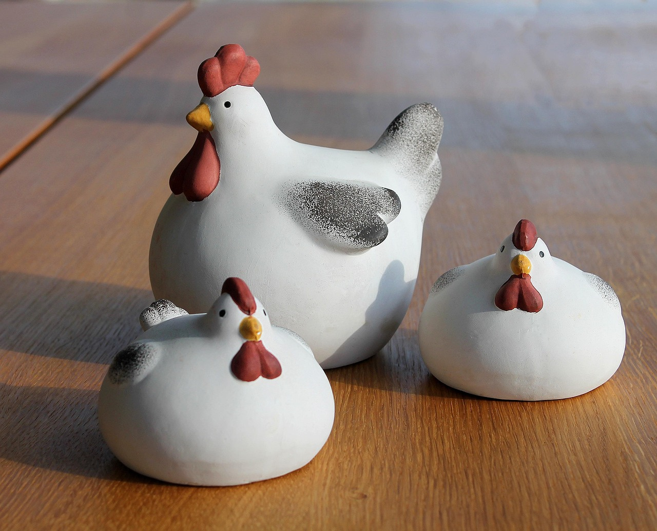 Eleganckie ceramiczne dekoracje wielkanocne i figurki kur z porcelany, dostępne w ofercie jako stylowe dodatki na komodę lub wielkanocny stół.