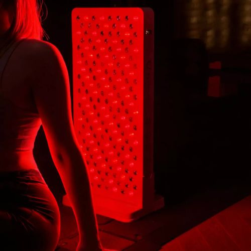 Terapia czerwonym światłem - Osoba korzystająca z domowej terapii RLT – sesja z lampą LED naświetlającą ciało w celu przyspieszenia regeneracji potreningowej.